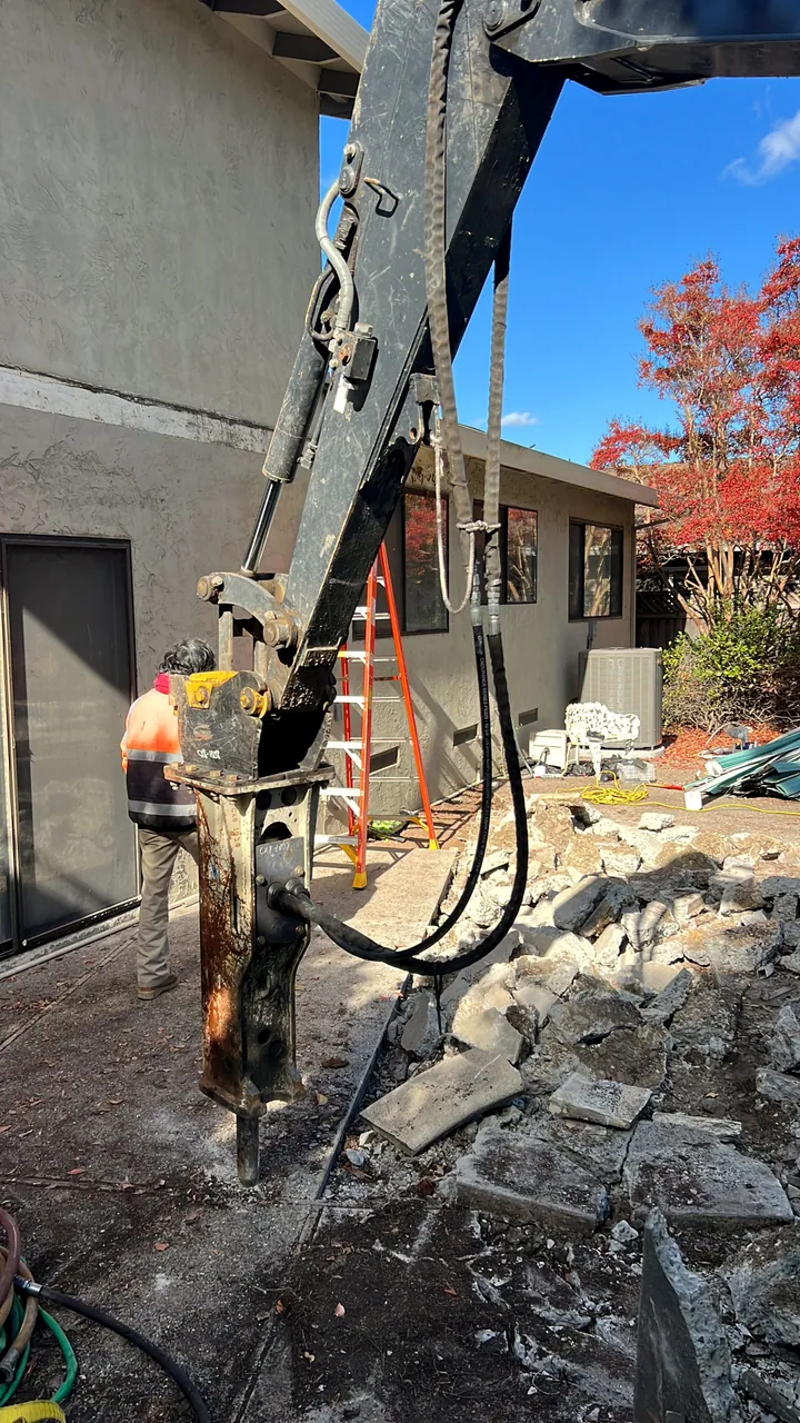 Excavator breaker working through concrete and rubble