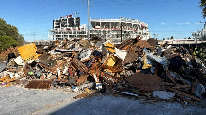 Demolition debris piled on the lot with Levi's Stadium behind