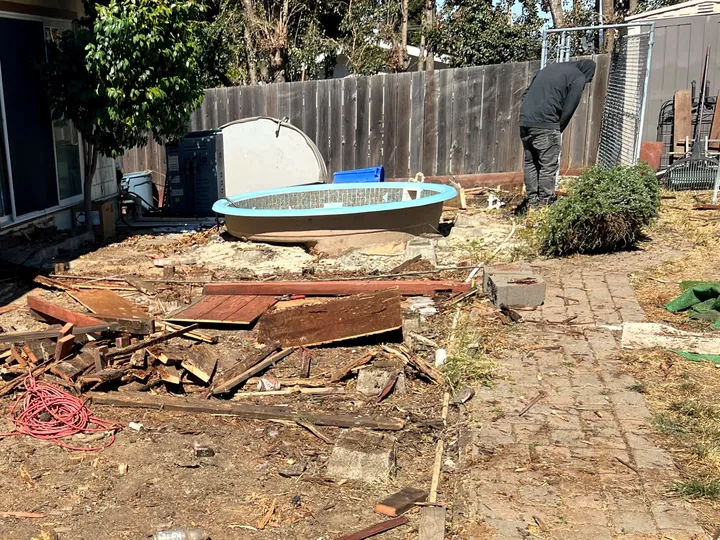 Old hot tub lifted out and the torn-out deck boards stacked ready to load