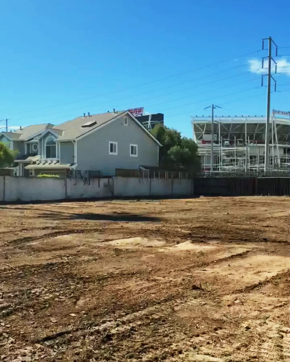 After: the same lot cleared to bare, graded dirt