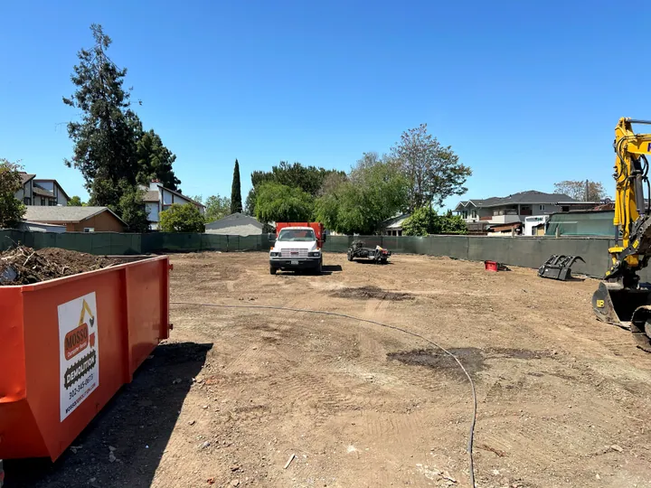 Mosso roll-off dumpster on a cleared demolition lot