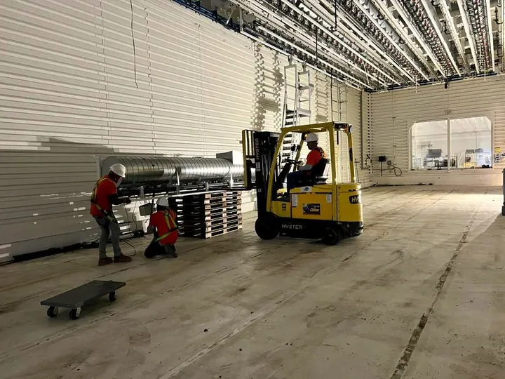 Panels and equipment unbolted and stacked inside a warehouse