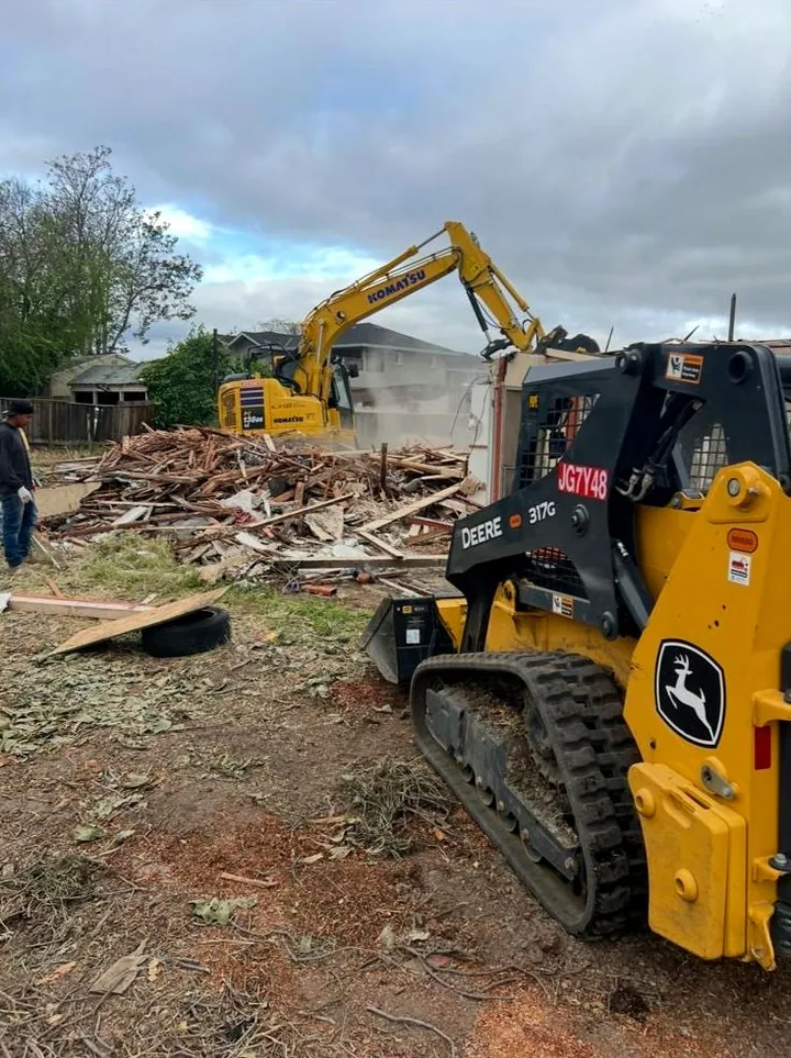 Deere skid steer and Komatsu excavator on a house demolition